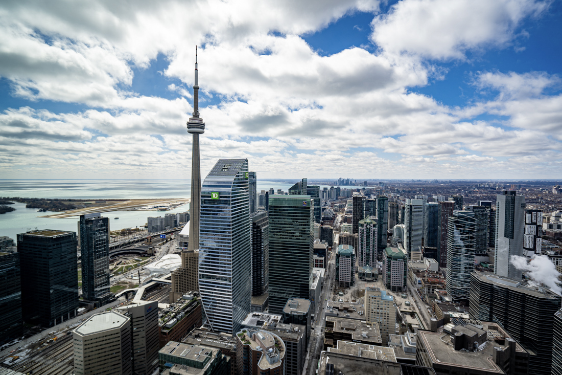 Canadian flag over city skyline at sunset Canada immigration