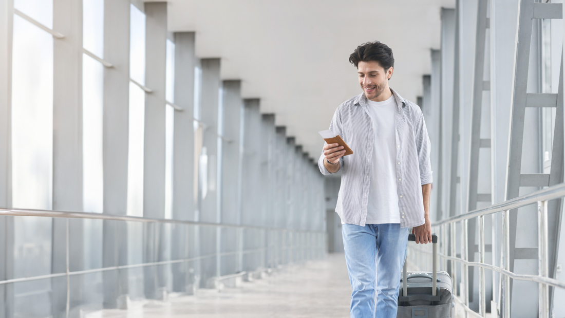 Newcomer holding passport and boarding pass to Canada