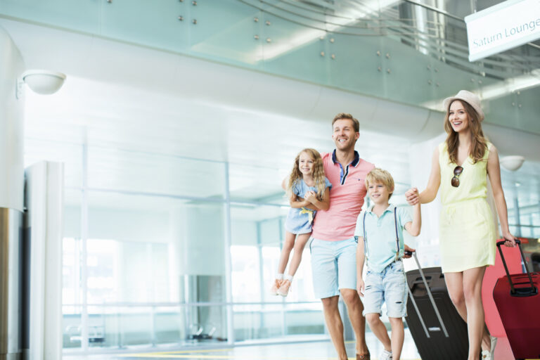 Happy newcomer family arriving with luggage at Canadian airport