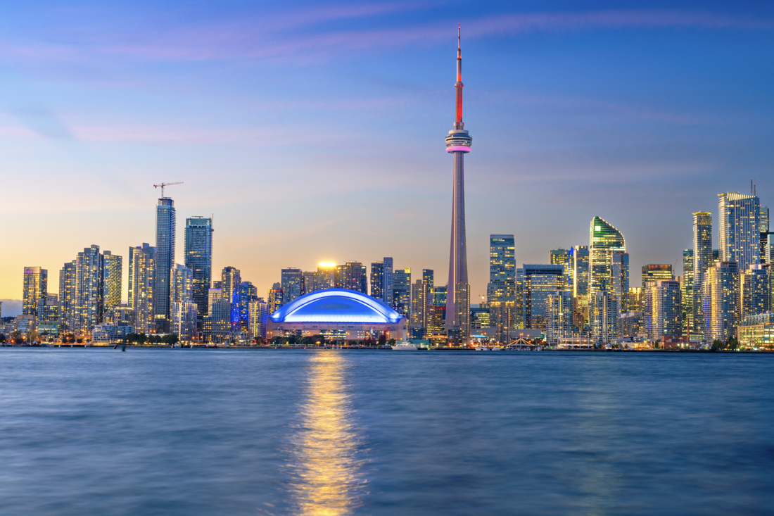 Newcomer with Canadian flag in canoe at mountain lake