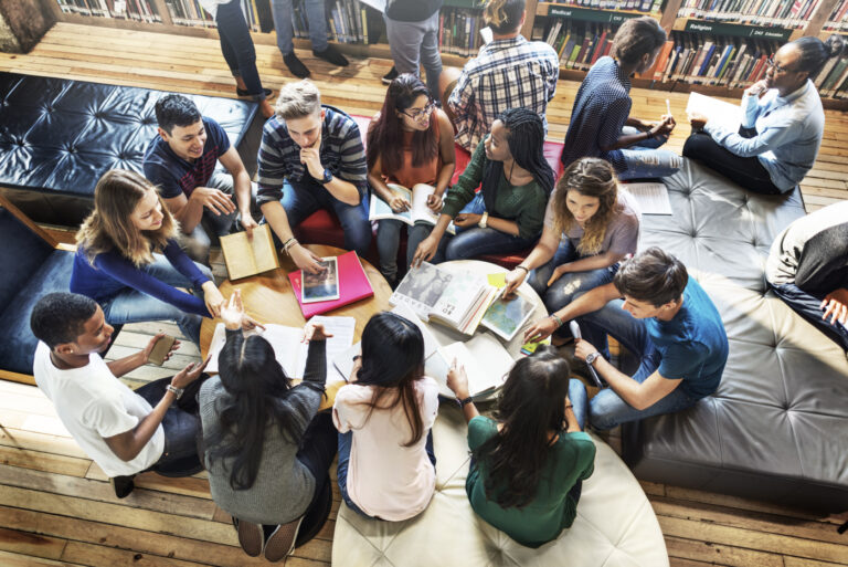 Diverse students discussing Canadian degree options in library