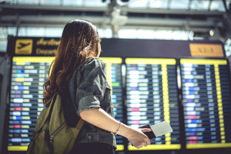 Newcomer checking departures with passport for TEF Canada exam