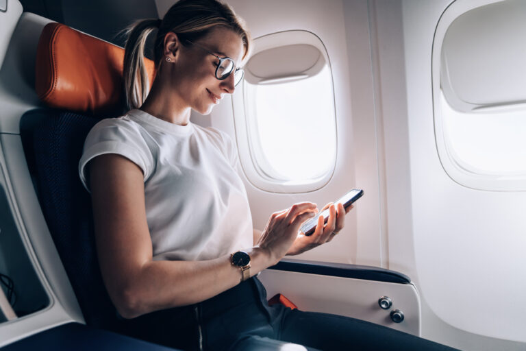 Newcomer flying to Canada reviewing visa details on phone