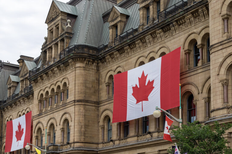 Historic Canadian government building with flags displayed