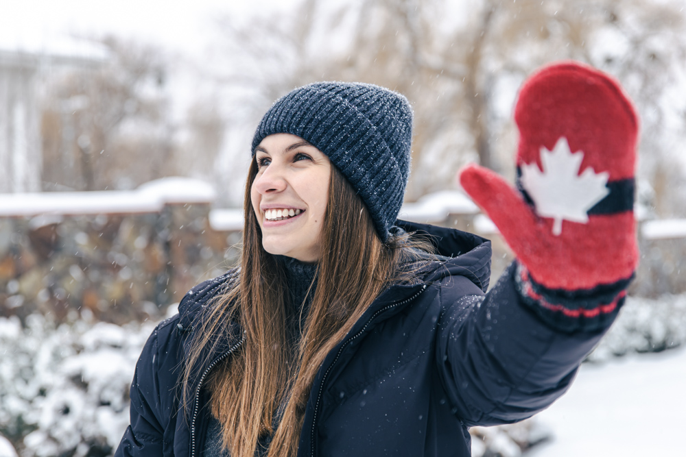 Newcomer holding Canadian flag by Atlantic coast