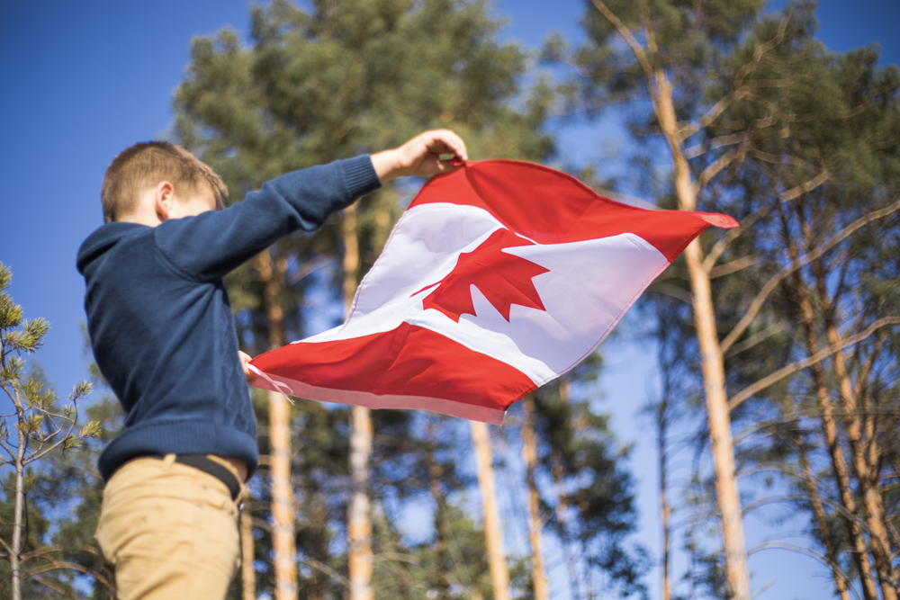 Hand holding maple leaf during Canadian autumn