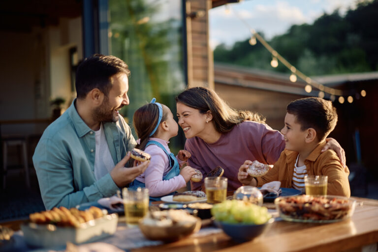 Happy family enjoying outdoor meal after child sponsorship approval