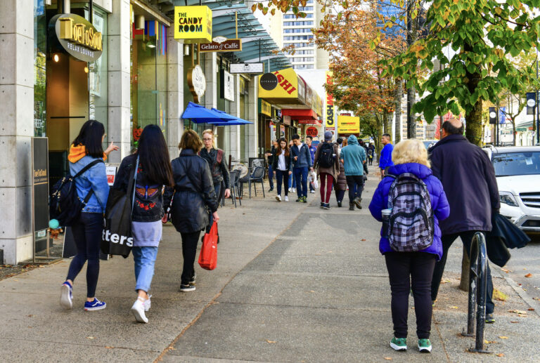 Multicultural pedestrians in fall jackets on Canadian city street