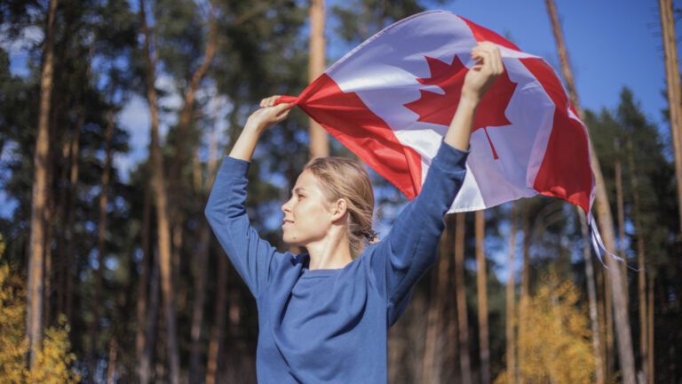 Person holding Canadian flag outdoors
