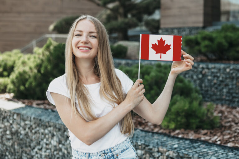 Happy newcomer holding Canadian flag