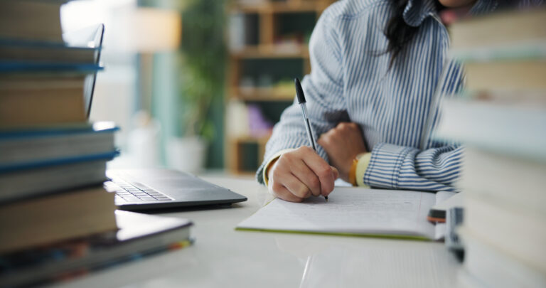 Student studying with laptop nearby