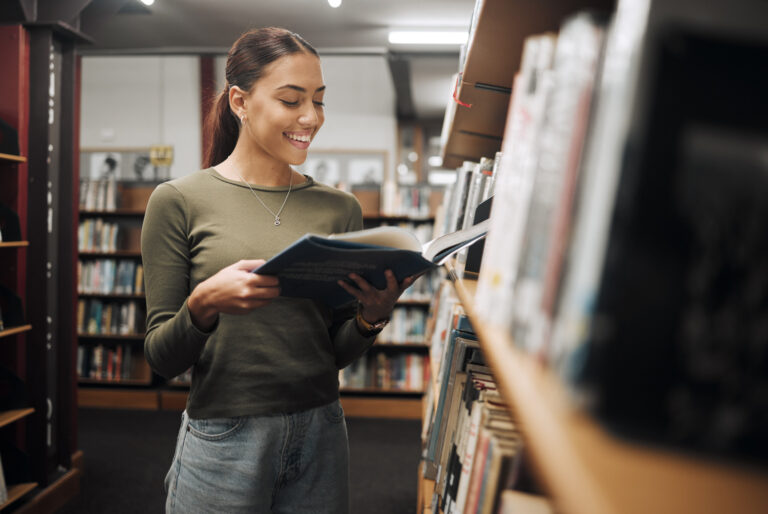 Young woman reading book in library