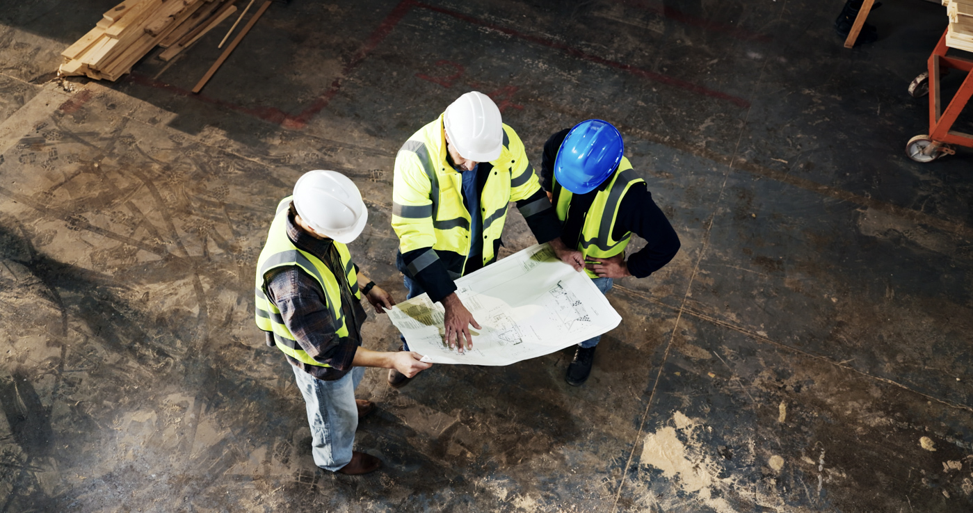 Construction workers review plans at worksite